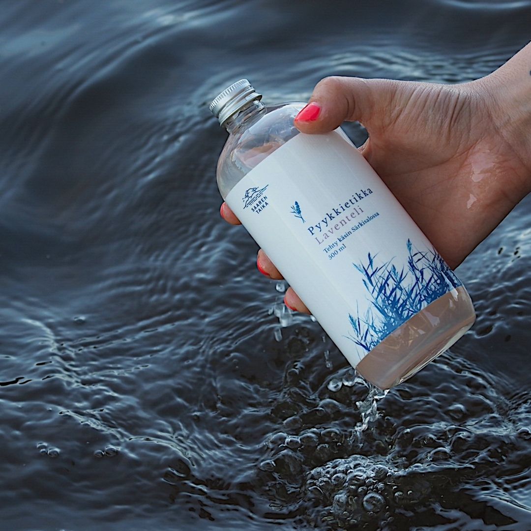 Käsi ottaa Saaren Taika Laventeli pyykkietikkaa vedestä